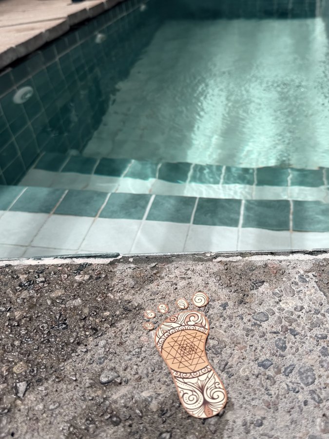 A Barefoot Sage footprint mark beside the steps of a cold plunge pool