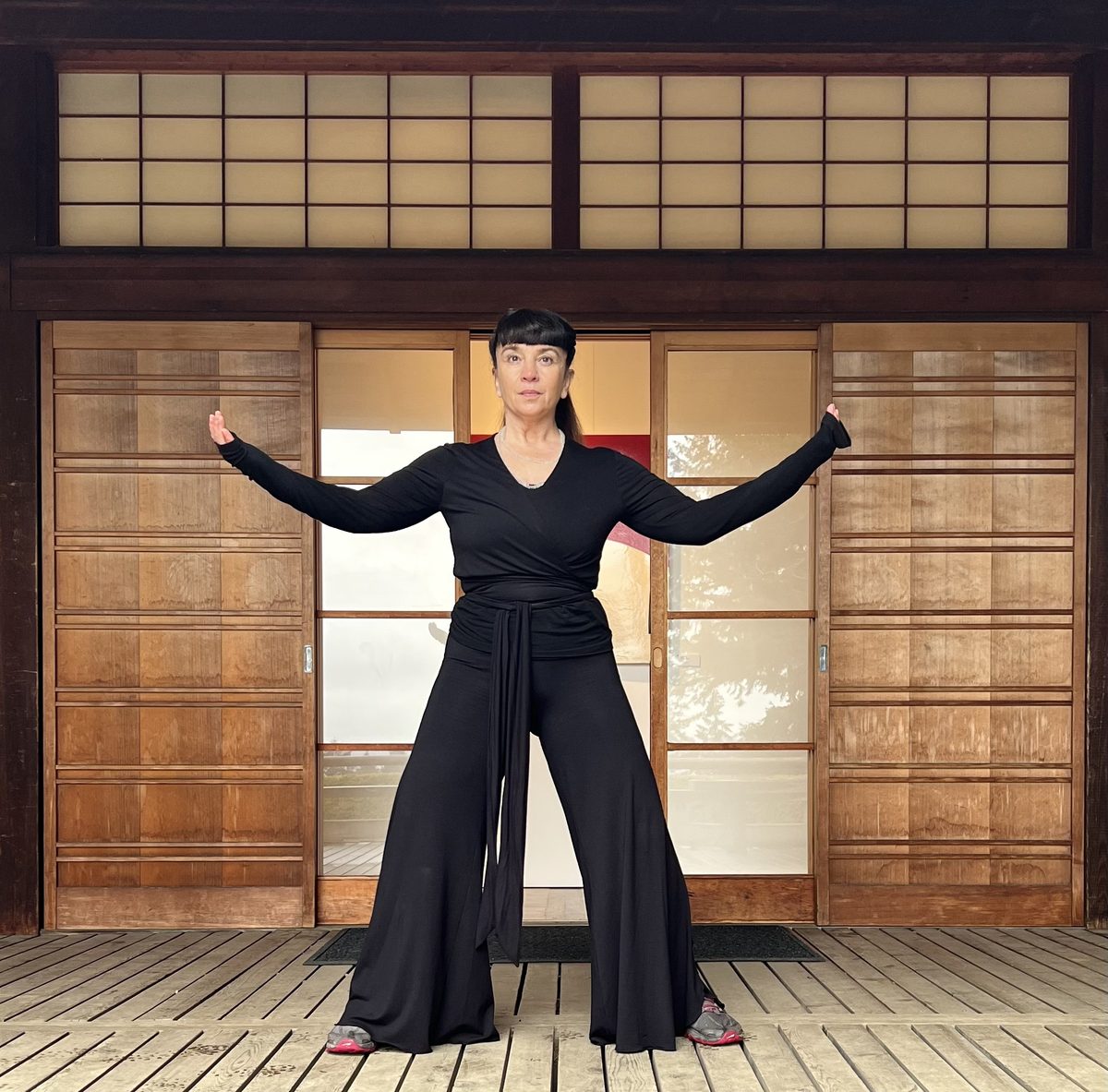 Dr. Sara Hazel practicing qi gong — gold light, slow form, the medicine moving through the body