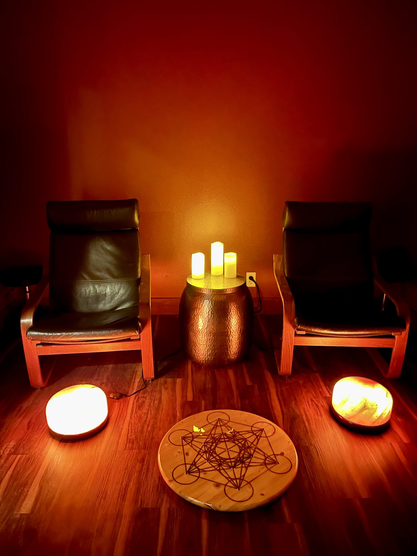 A treatment room at Barefoot Sage Center — leather chairs, candlelight, and glowing Himalayan salt domes